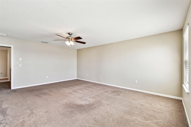 unfurnished room featuring carpet flooring, visible vents, and baseboards