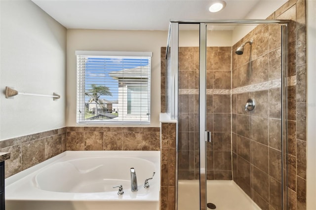 bathroom featuring a shower stall and a bath