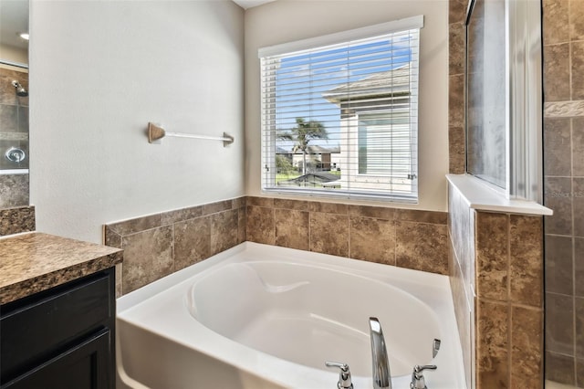 full bathroom featuring a garden tub, a tile shower, and vanity