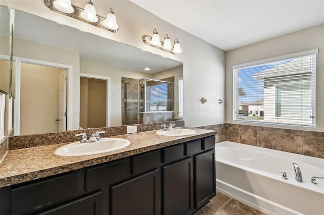 bathroom with a garden tub, a sink, a shower stall, and double vanity