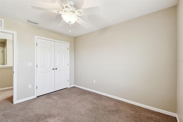 unfurnished bedroom with carpet floors, baseboards, visible vents, and a closet