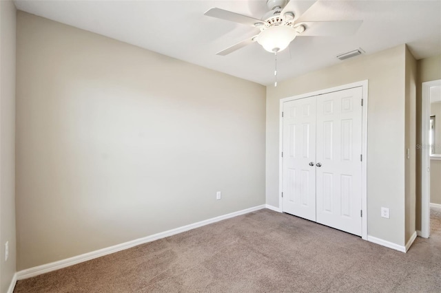 unfurnished bedroom with a closet, carpet flooring, visible vents, and baseboards