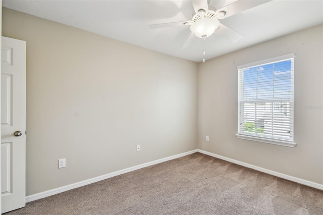 spare room featuring carpet, baseboards, and a ceiling fan