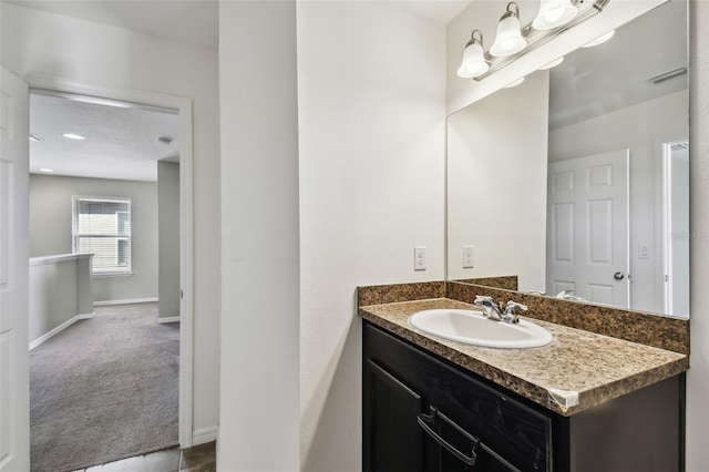 bathroom featuring visible vents, vanity, and baseboards