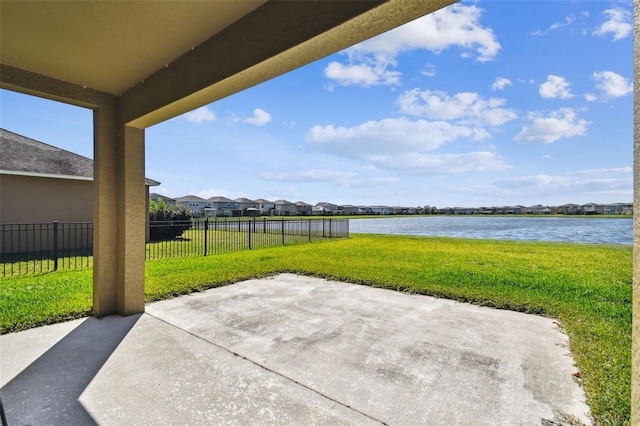 view of patio / terrace with a water view, fence, and a residential view