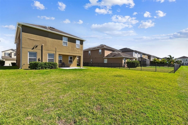 back of house featuring a yard, a patio area, fence, and stucco siding