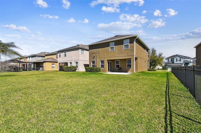 back of house featuring a yard, fence, a patio, and stucco siding