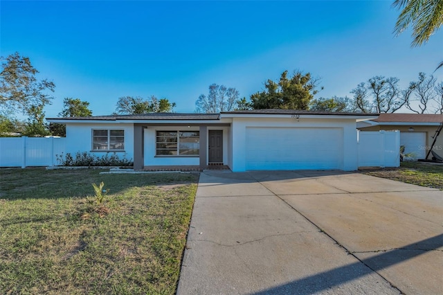 ranch-style home featuring a garage, fence, a front lawn, and stucco siding