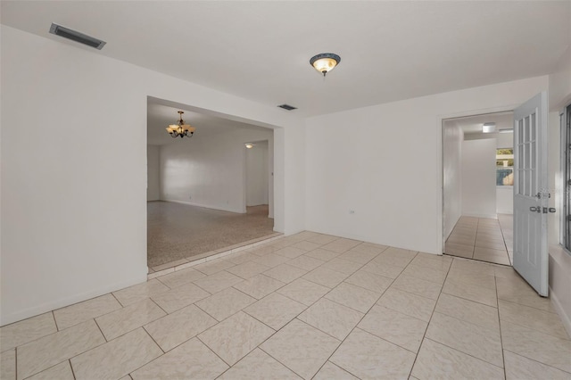 unfurnished room featuring visible vents, an inviting chandelier, and light tile patterned flooring