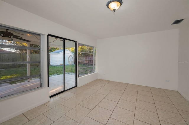 spare room featuring light tile patterned floors, visible vents, and a ceiling fan