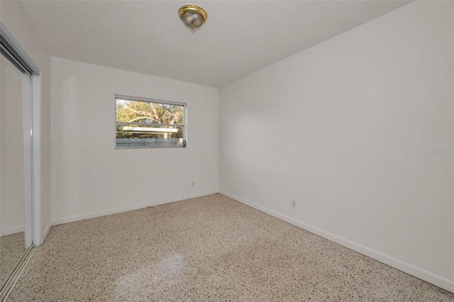 spare room featuring baseboards and speckled floor