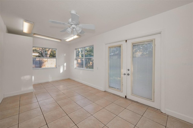 unfurnished room with french doors, ceiling fan, baseboards, and light tile patterned floors