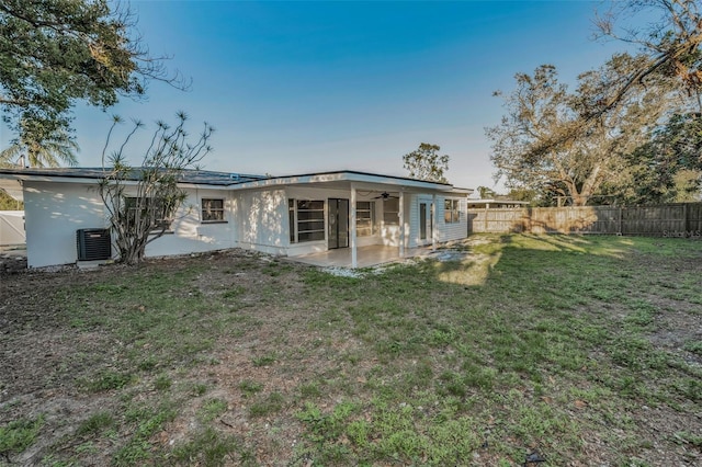 back of house with a patio area, a fenced backyard, a lawn, and ceiling fan