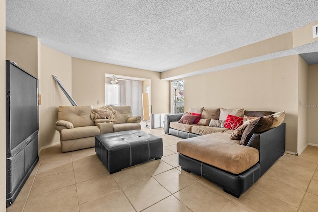 living area featuring a textured ceiling and light tile patterned floors