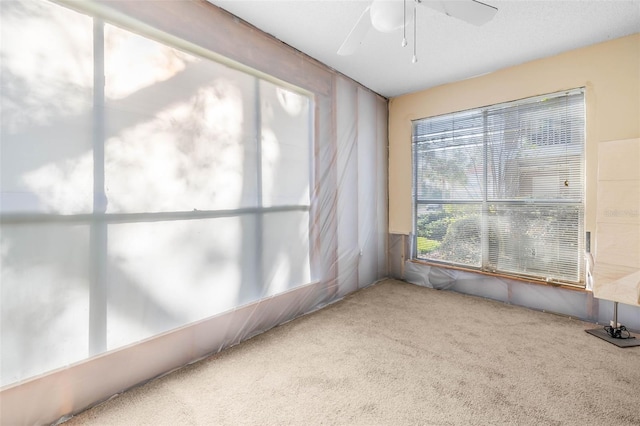 unfurnished sunroom featuring a ceiling fan