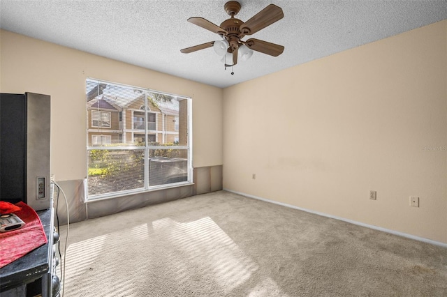 interior space featuring carpet floors, a ceiling fan, and a textured ceiling