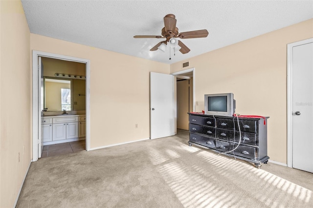 bedroom with carpet, visible vents, a sink, and a textured ceiling