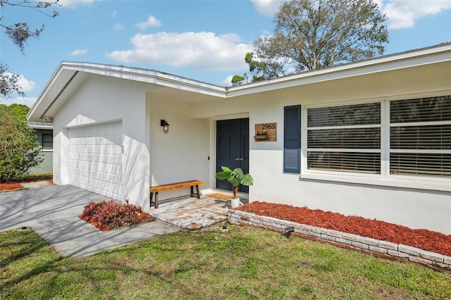 view of front of house with stucco siding, an attached garage, and driveway