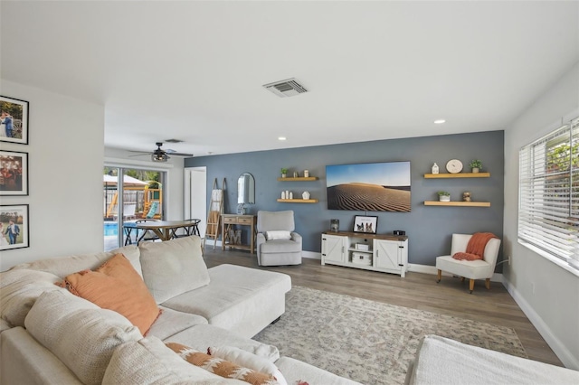 living room with visible vents, plenty of natural light, baseboards, and wood finished floors