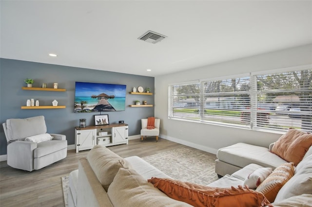 living area featuring recessed lighting, wood finished floors, visible vents, and baseboards