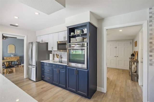 kitchen with visible vents, light countertops, light wood-style flooring, appliances with stainless steel finishes, and white cabinetry