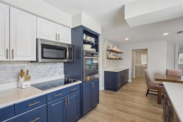 kitchen with open shelves, blue cabinetry, white cabinets, and stainless steel appliances