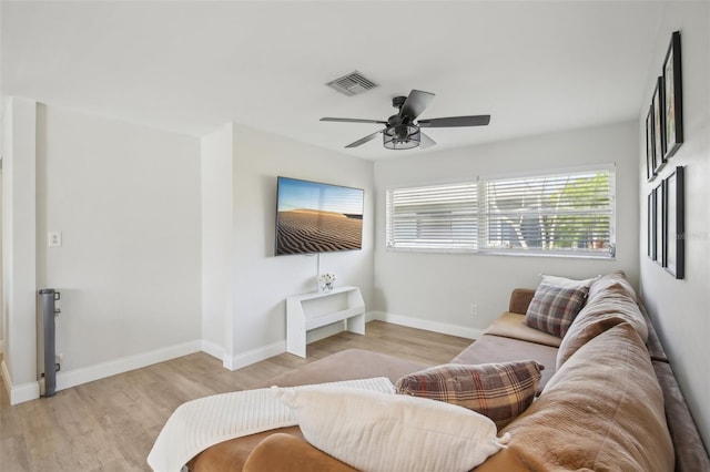 living area featuring visible vents, baseboards, light wood-style flooring, and a ceiling fan