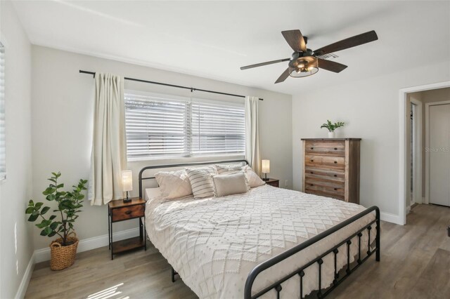 bedroom with wood finished floors, baseboards, and ceiling fan