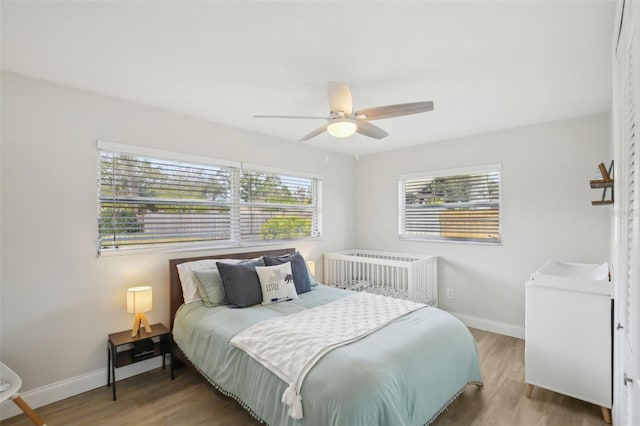 bedroom with wood finished floors, baseboards, and ceiling fan