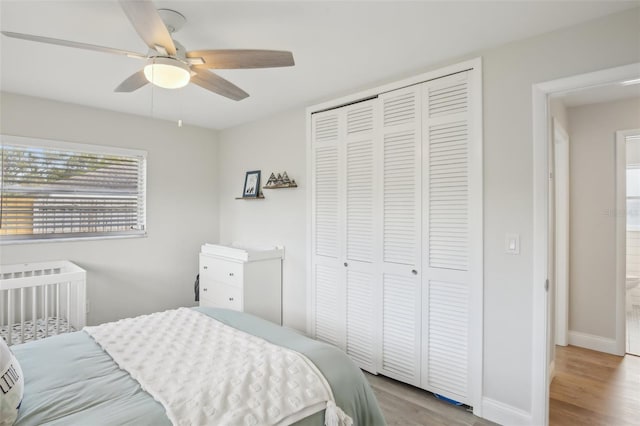 bedroom featuring ceiling fan, wood finished floors, a closet, and baseboards