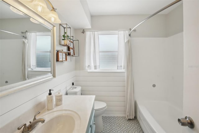 full bathroom with vanity, shower / bathtub combination with curtain, wood walls, wainscoting, and toilet