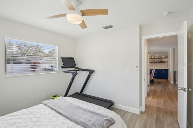 bedroom with visible vents, baseboards, light wood finished floors, and ceiling fan