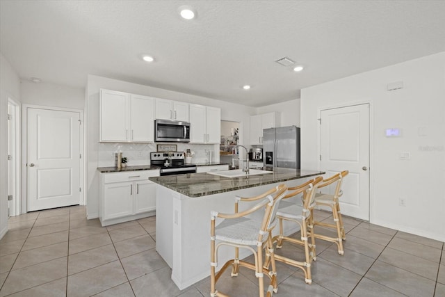 kitchen with stainless steel appliances, a breakfast bar, a sink, and white cabinets