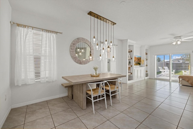 dining room with light tile patterned flooring, ceiling fan, a textured ceiling, and baseboards