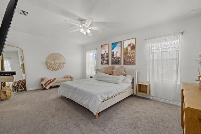 bedroom with light carpet, baseboards, visible vents, and a ceiling fan