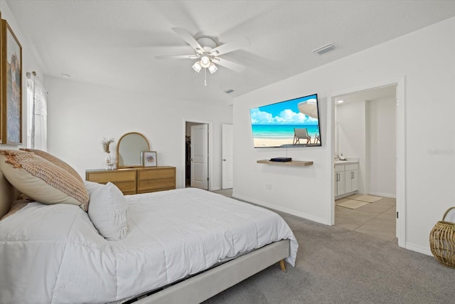 carpeted bedroom featuring a ceiling fan, baseboards, visible vents, and connected bathroom