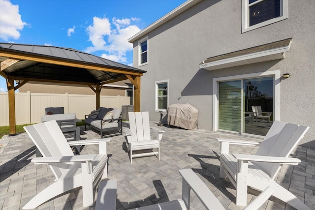 view of patio featuring a grill, fence, a gazebo, and an outdoor hangout area