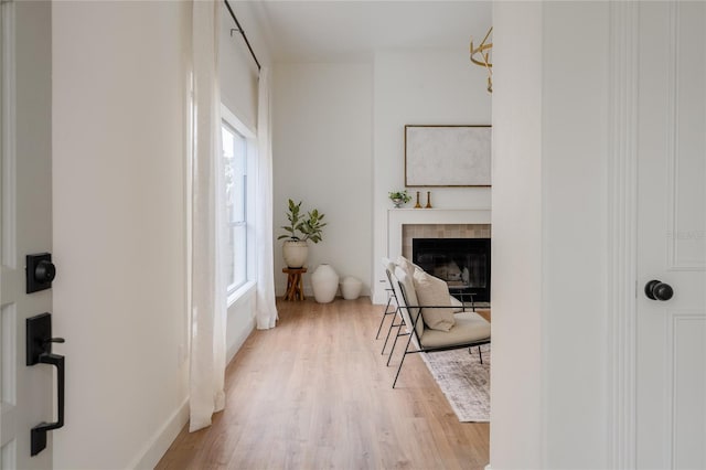 sitting room with light wood-style flooring and a tiled fireplace