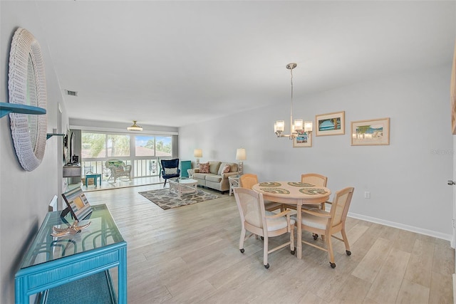 dining room with visible vents, baseboards, a notable chandelier, and light wood finished floors