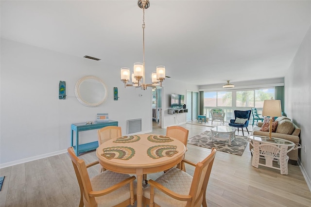 dining room with visible vents, baseboards, light wood-style floors, and a notable chandelier