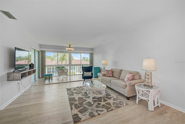 living area featuring light wood-type flooring, baseboards, and visible vents