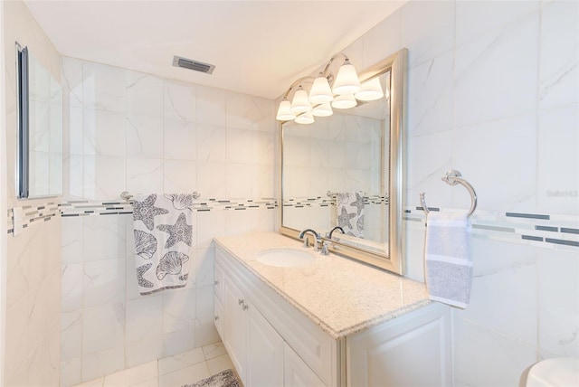 bathroom featuring vanity, tile walls, and visible vents