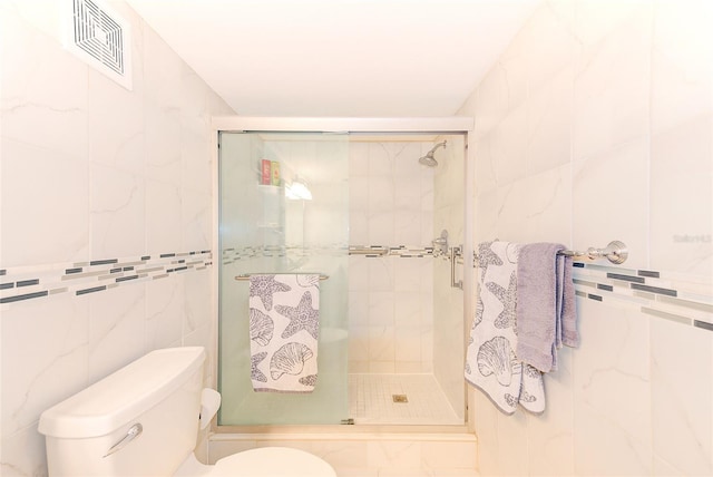 bathroom featuring visible vents, a shower stall, toilet, and tile walls