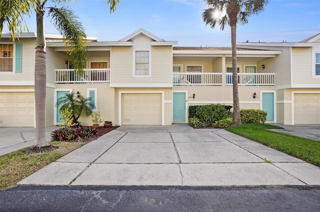 multi unit property with a garage, concrete driveway, and stucco siding