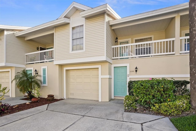 multi unit property with concrete driveway, an attached garage, and stucco siding