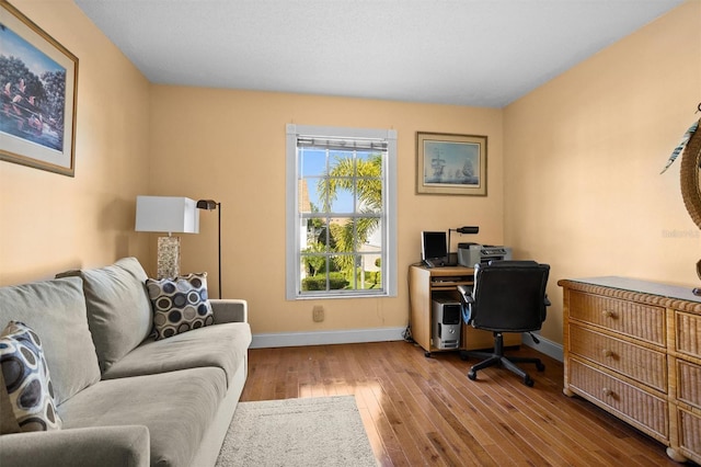 home office with hardwood / wood-style flooring and baseboards