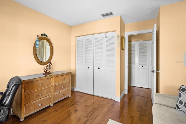 office space with baseboards, visible vents, and wood-type flooring