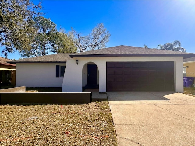 ranch-style house with a garage, concrete driveway, and stucco siding