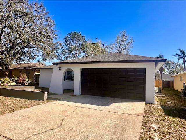 single story home featuring driveway, central AC unit, an attached garage, and stucco siding