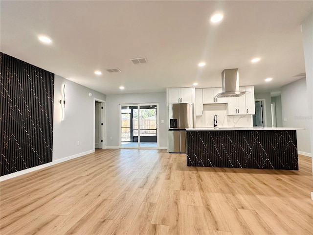 kitchen with stainless steel fridge, a sink, visible vents, and extractor fan